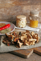 Obraz na płótnie Canvas Dried mushrooms with spices on wooden background
