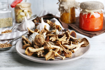 Dried mushrooms in plate on wooden background