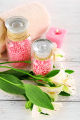 Spa still life with flower and candle on wooden table, closeup