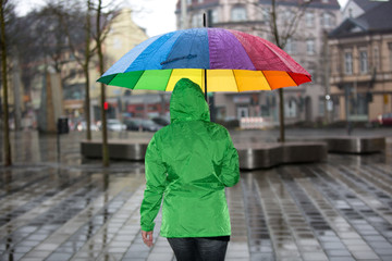 Spaziergang durch die Stadt bei Regen mit buntem Schirm
