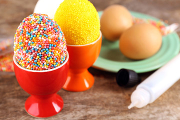 Decoration Easter eggs with colorful beads on wooden table, closeup