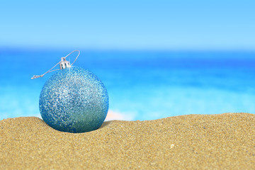 Fototapeta na wymiar Christmas ball on sandy beach