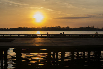 Sunset over the lake and wooden deck