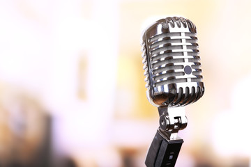 Retro microphone on bright blurred background