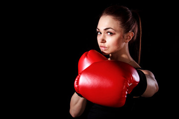 Beautiful young woman in red boxing gloves
