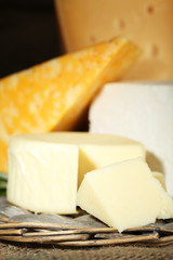 Different sort of cheese on wicker tray, closeup