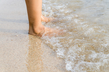 Woman feet on the beach with natural evening