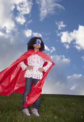 little girl superhero against blue sky