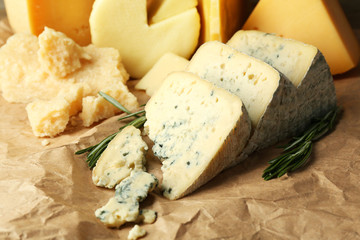 Various types of cheese with rosemary on table close up