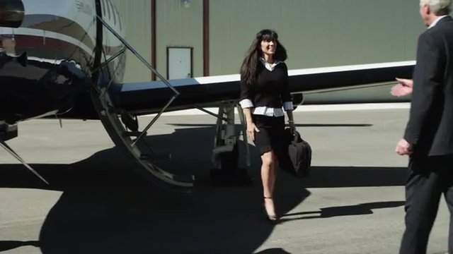 WS PAN MS Businesswoman disembarking private airplane and shaking hand with businessman / Spanish Fork, Utah, USA