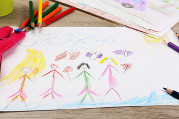 Kids drawing on white sheet of paper with crayon,closeup