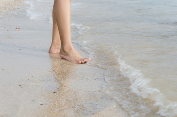 Woman feet on the beach with natural evening light