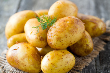 raw baby potatoes on wooden surface