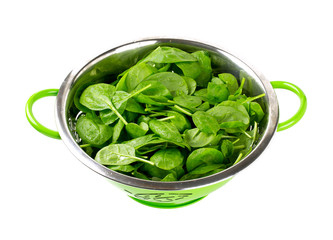 fresh spinach leaves in green colander