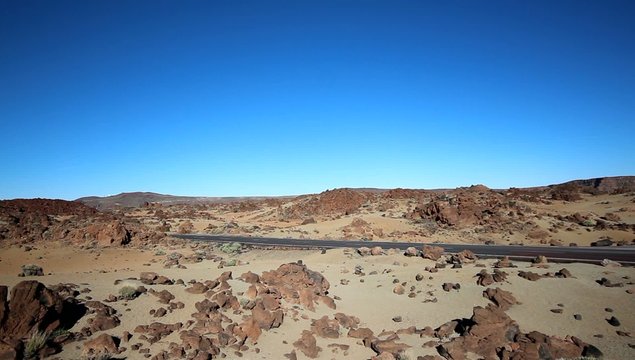 red oldtimer car drives through desert landscape - Teide