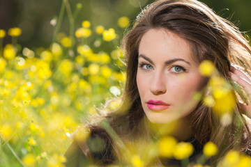 Beautiful young girl among yellow flowers