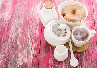 Tea cups with teapot on old wooden table