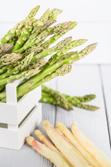 Fresh green asparagus in a wooden box on a light wooden background