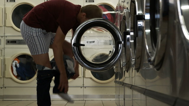 Man Taking Off Pants At A Laundromat