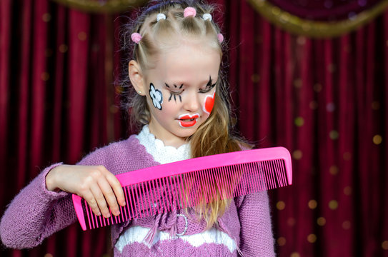 Girl with Face Painted Brushing Hair with Big Comb