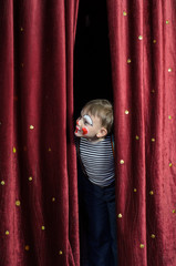 Boy Dressed Up as Clown Peeking Thru Stage Curtain