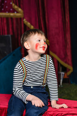 Cute excited little boy in comic red makeup