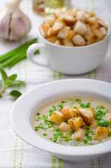 Garlic soup with croutons, spring onions and chives