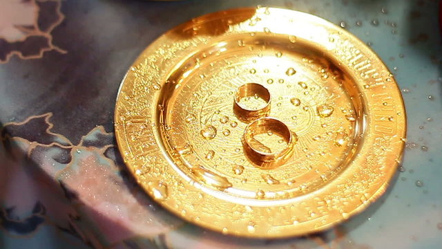 wedding rings on a golden platter