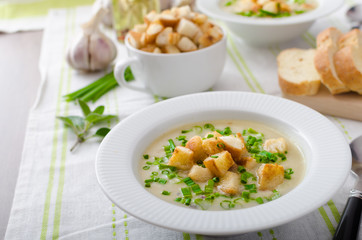 Garlic soup with croutons, spring onions and chives