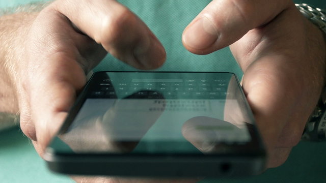 Close- up hands typing text messages on smart phone