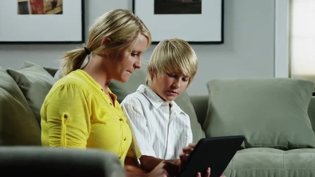 MS DS Mother and son (10-11) using ipad on sofa / Orem, Utah, USA