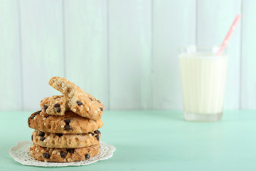Tasty cookies and glass of milk on color wooden background