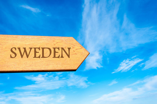 Wooden arrow sign pointing destination SWEDEN