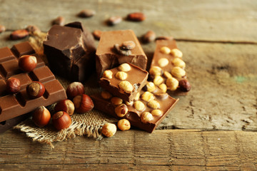 Still life with set of chocolate with nuts on wooden table, closeup