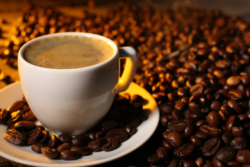 Cup of coffee with grains, closeup