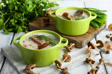 Mushroom soup with greens on wooden table, closeup