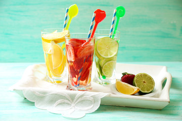 Cocktails with fresh strawberries and lemons on wooden background