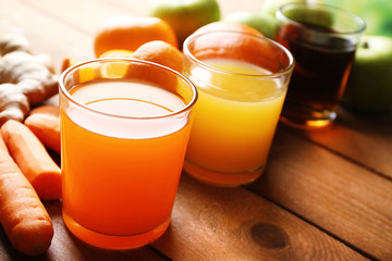 Assortment of healthy fresh juices and fruits on wooden table background
