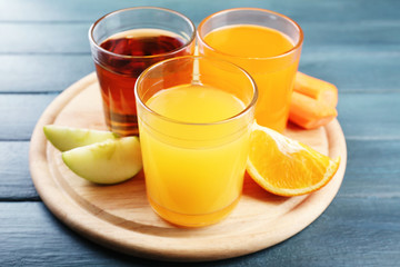 Assortment of healthy fresh juices and fruits on wooden table background