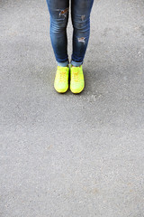 Female feet over gray asphalt background