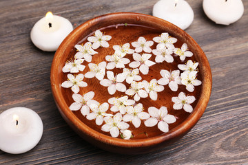 Spa still life with petals and candlelight on wooden background