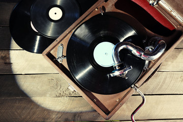 Gramophone with vinyl record on wooden table, top view