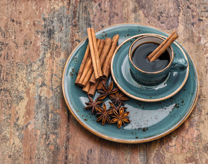 Cup of black coffee with cinnamon and star anise spices