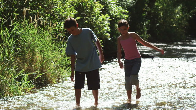 children wading in a river