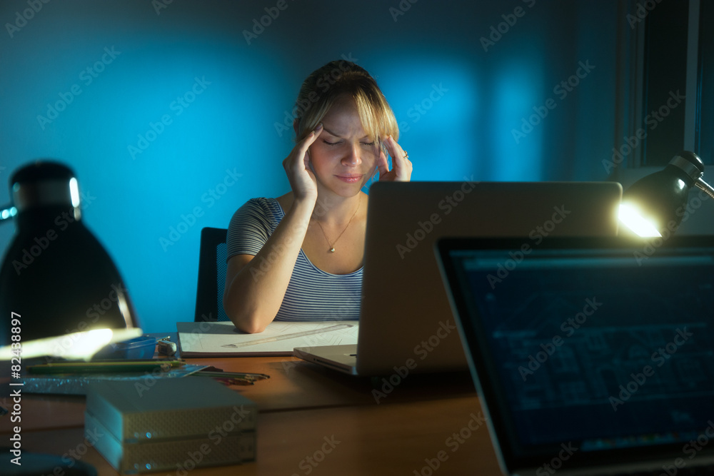 Wall mural woman with eyes tired working late at night in office