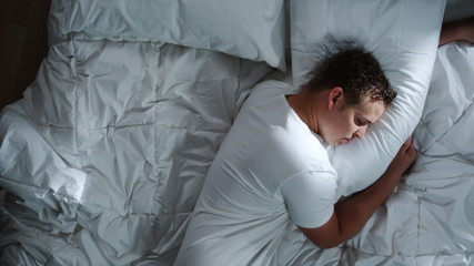 man sleeping in bed - Powered by Adobe