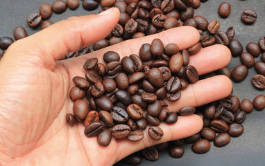 Coffee beans and hand on paper background