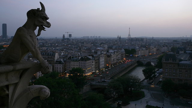 timelapse of paris street and canal traffic at dusk as a gargoyle looks on