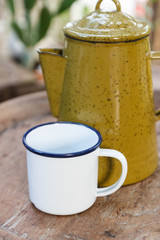 white cup and old yellow jug and tiffin