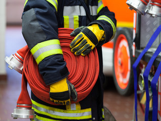 Feuerwehrmann Feuerwehrwache mit Wasserschlauch in der Hand - 82447638